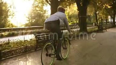 难得看到年轻人在公园里骑自行车，用黑色耳机听音乐。 一个人骑着自行车